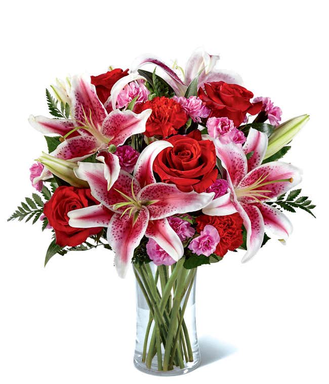 Pink asiatic lilies, red roses and red carnations in colorful vase