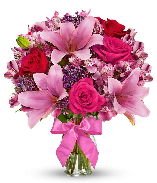 Red roses, pink lilies and pink alstroemeria and glass vase