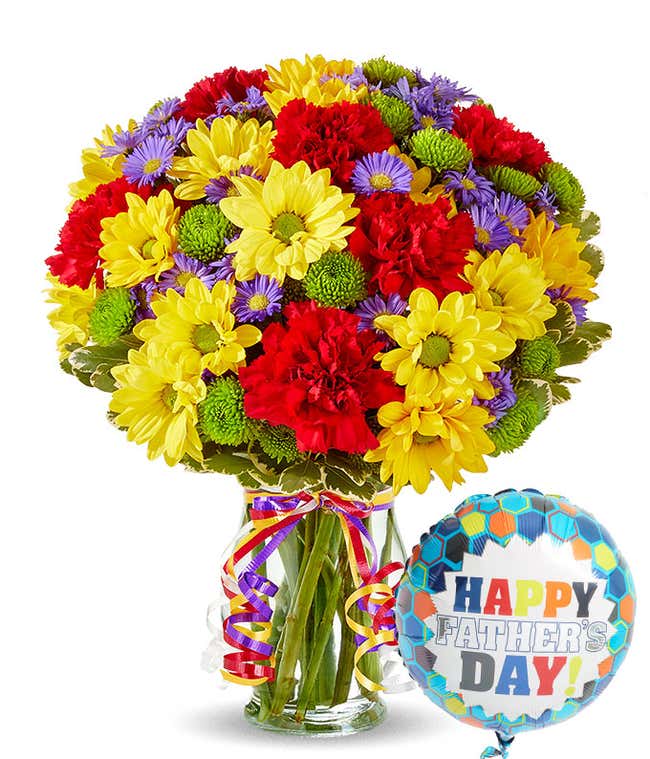 bouquet of Yellow daisies, red carnations and green button pops in a glass vase along with a happy father's day balloon