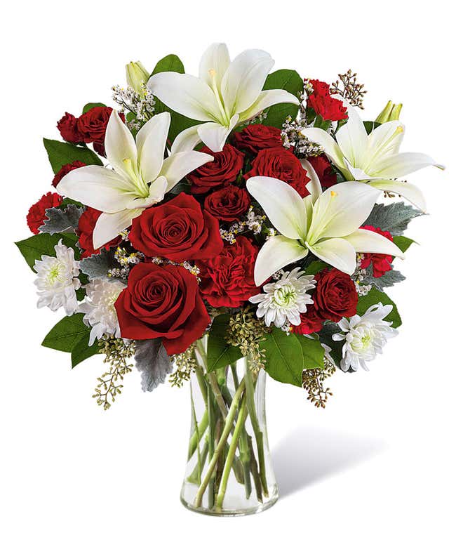 Bouquet of red roses and white lilies, in a sparkly red vase.