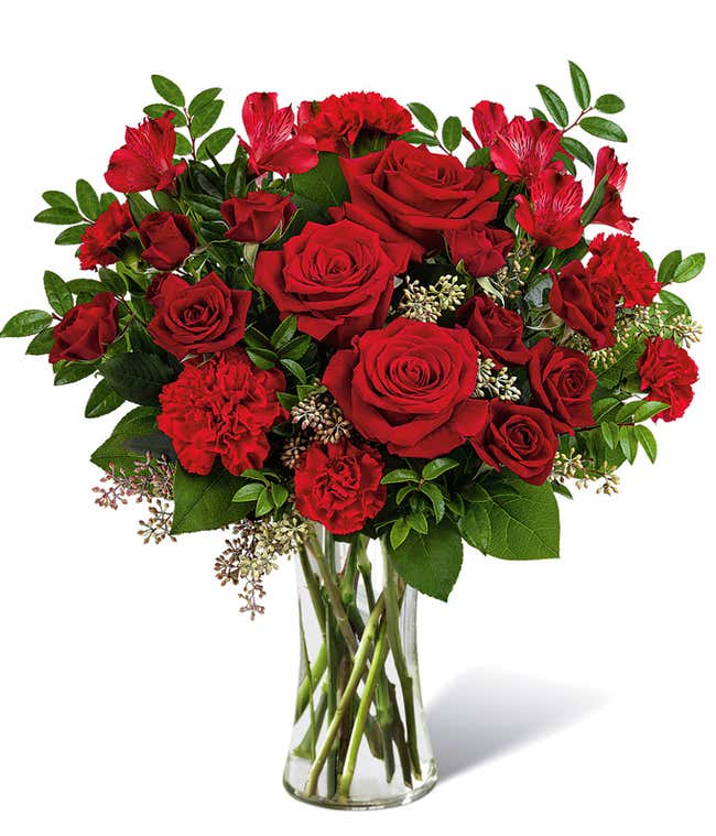 Full arrangement of red roses and carnations in a tall red mosaic vase,