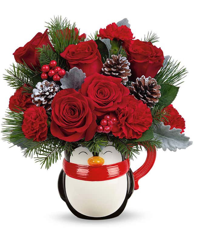 A festive arrangement with red roses, red carnations, floral greens, berries, and pinecone picks.