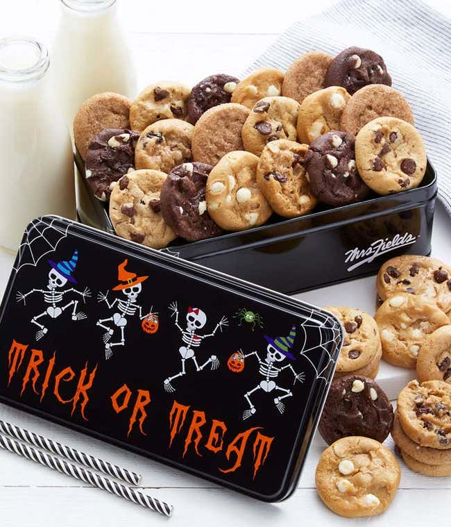 A tin of 30 assorted bite sized cookies packed into a black tin that says trick or treat, with dancing skeletons.