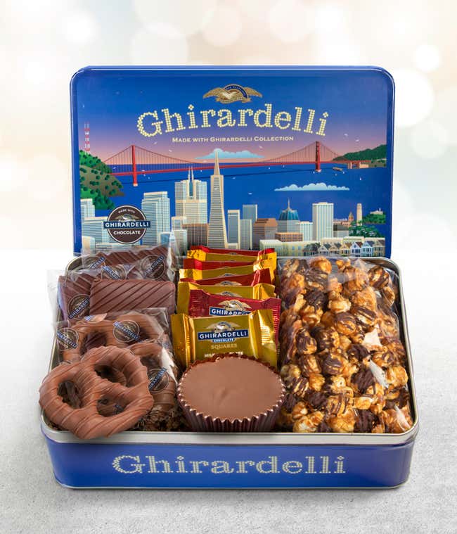  Ghirardelli gift tin featuring milk chocolate-covered pretzels, dark chocolate graham crackers, assorted Ghirardelli chocolate squares, a large milk chocolate peanut butter cup, and dark chocolate sea salt caramel popcorn, elegantly displayed in a tin