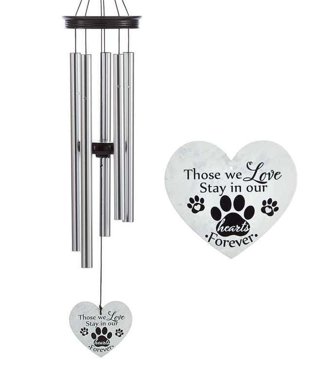 A windchime with metal rods and a wooden accents and heart shaped sail. White sail reads those we love stay in our hearts forever with black hearts and pawprints.