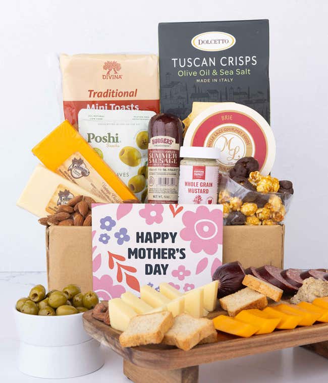 A charcuterie gift box with assorted cheeses, summer sausage, olives, crackers, mustard, almonds, and chocolate treats finished with a 'Happy Mother's Day' card.