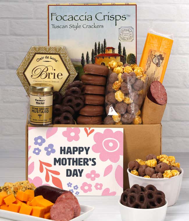A box filled with 2 cheeses, summer sausage, crackers, chocolate pretzels, caramel corn, and chocolate covered Oreos with a 'Happy Mother's Day' card.