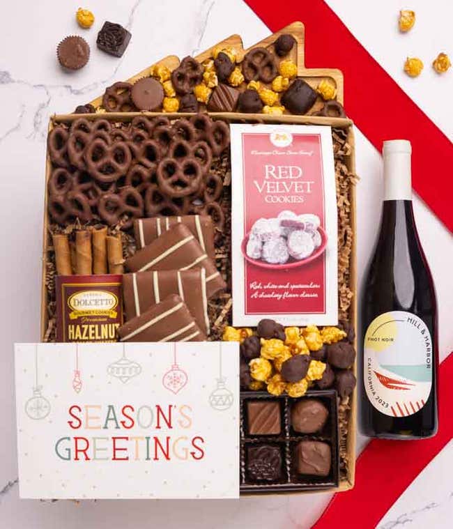 A holiday gift set with abottle of Hill &amp; Harbor Pinot Noir, a box of assorted chocolates, a bag of chocolate-covered pretzels, a box of mini chocolate chip cookies, and a Season's Greetings message card.
