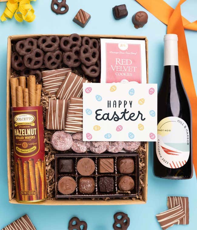 A bottle of Hill &amp; Harbor Pinot Noir is displayed alongside a box of assorted chocolates, chocolate-covered pretzels, and mini chocolate chip cookies finished with a Happy Easter card.