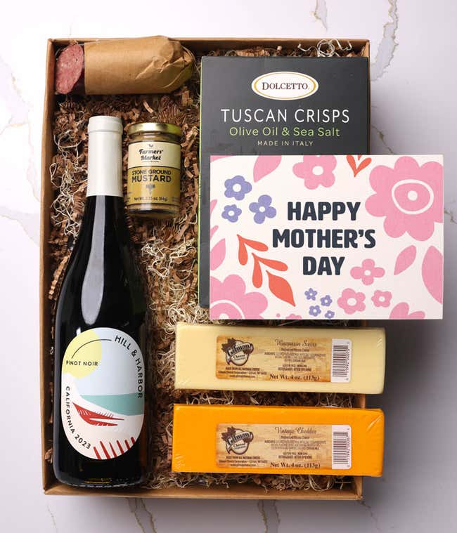 A snack and wine gift box featuring 2 cheeses - chaddar &amp; Swiss, cracker crisps, summer sausage, mustard, and a bottle of red wine. A 'Happy Mother's Day,' sits on top. A perfect gift for Mom.
