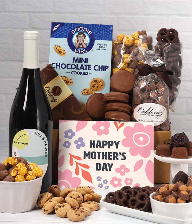 A bottle of Hill &amp; Harbor Pinot Noir sits beside chocolate-covered pretzels, mini chocolate chip cookies, caramel popcorn, assorted chocolates, mini buckeyes, chocolate covered Oreos, and a Happy Mother's Day card.