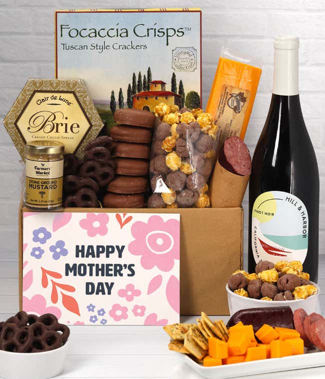 A spread featuring Hill &amp; Harbor Pinot Noir, 2 cheeses, summer sausage, crackers, chocolate pretzels, caramel corn, and chocolate covered Oreos with a 'Happy Mother's Day' card.