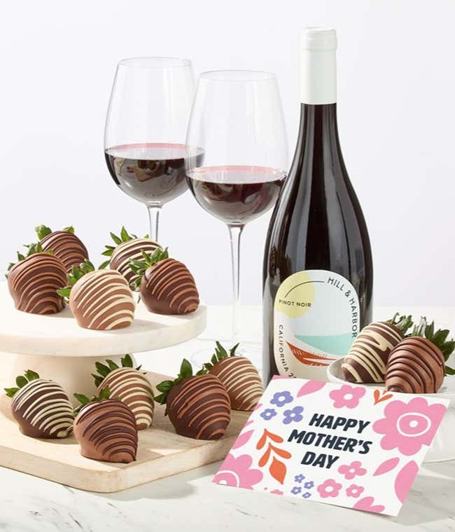 Hill &amp; Harbor Pinot Noir bottle displayed with two glasses of red wine and assorted chocolate-covered strawberries on trays, styled with a floral Happy Mother&rsquo;s Day card for an elegant dessert and wine gift.
