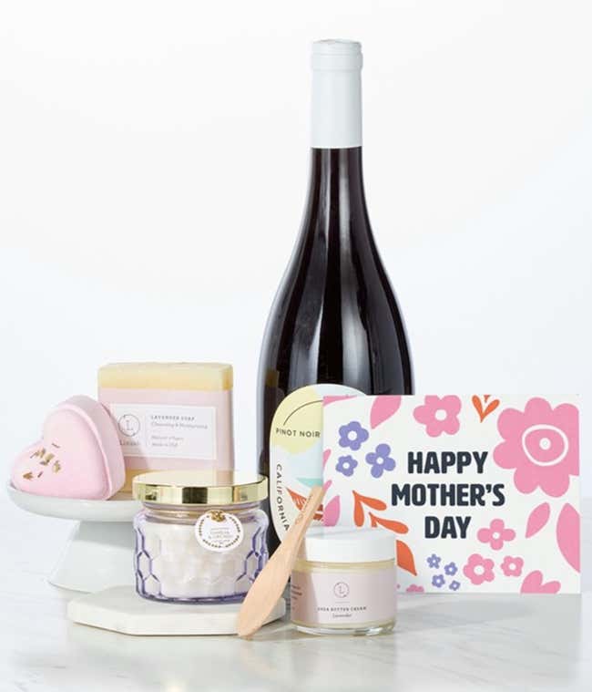 Hill &amp; Harbor California Pinot Noir paired with spa essentials including artisan lavendar soap, a heart-shaped shower steamer, shea butter cream with wooden scoop, and a candle arranged in a clean display with a Mother's Day card.