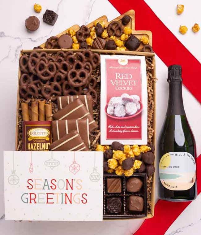 A holiday gift set with abottle of Hill &amp; Harbor Pinot Noir, a box of assorted chocolates, a bag of chocolate-covered pretzels, a box of mini chocolate chip cookies, and a Season's Greetings message card.