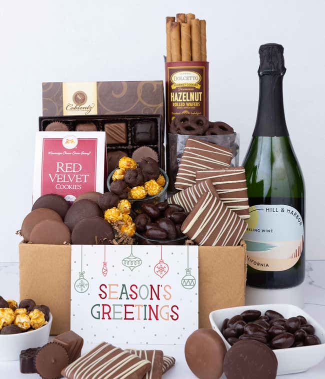 A gift set featuring a bottle of California Sparkling Wine paired with chocolate-covered pretzels, mini cookies, caramel popcorn, chocolate peanut butter buckeyes, 6 chocolate-covered Oreos, a box of assorted chocolates, and Season's Greetings card.