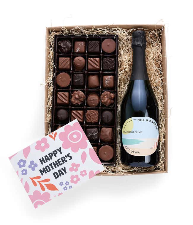 A gift box with Hill &amp; Harbor Sparkling wine and a 1 lb. box of assorted artisan chocolates with a 'Happy Mother's Day' card placed on top.