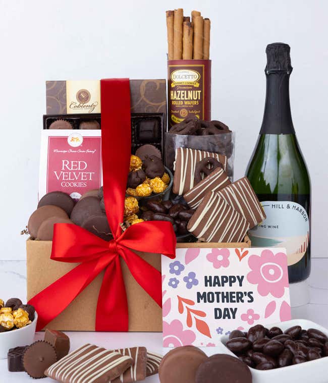 A bottle of Hill &amp; Harbor Sparkling wine sits beside chocolate-covered pretzels, mini chocolate chip cookies, caramel popcorn, assorted chocolates, mini buckeyes, chocolate covered Oreos , and a Happy Mother's Day card.