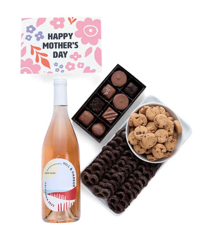 A bottle of Hill &amp; Harbor ros&eacute; wine, a box of assorted chocolates, chocolate-covered pretzels, and mini chocolate chip cookies with a 'Happy Mother's Day' card placed above.
