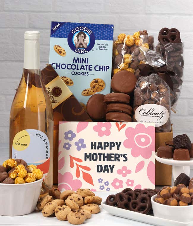 A bottle of Hill &amp; Harbor Ros&eacute; sits beside chocolate-covered pretzels, mini chocolate chip cookies, caramel popcorn, assorted chocolates, mini buckeyes, chocolate covered Oreos, and a Happy Mother's Day card.