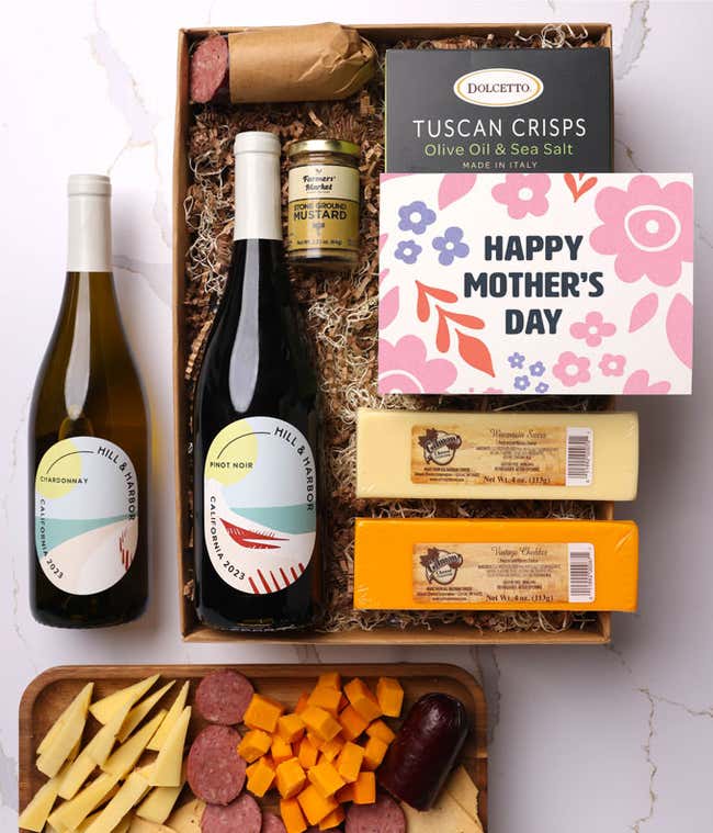 A snack and wine gift box featuring 2 bottles of wine - red and white, 2 cheeses - chaddar &amp; Swiss, cracker crisps, summer sausage, and mustard. A 'Happy Mother's Day,' sits on top. A perfect gift for Mom.