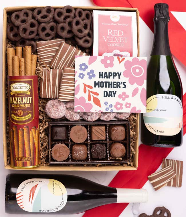 Bottles of Hill &amp; Harbor Pinot Noir and Sparkling wine paired with chocolate covered pretzels, mini chocolate chip cookies, a box of chocolates, and a 'Happy Mother's Day' card.