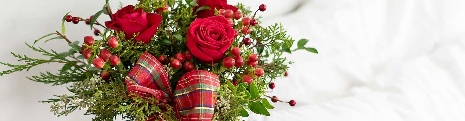 Christmas greenery with red berries on a white table